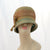 V988 Vintage: Schiaparelli, green/brown braid cloche, 22"